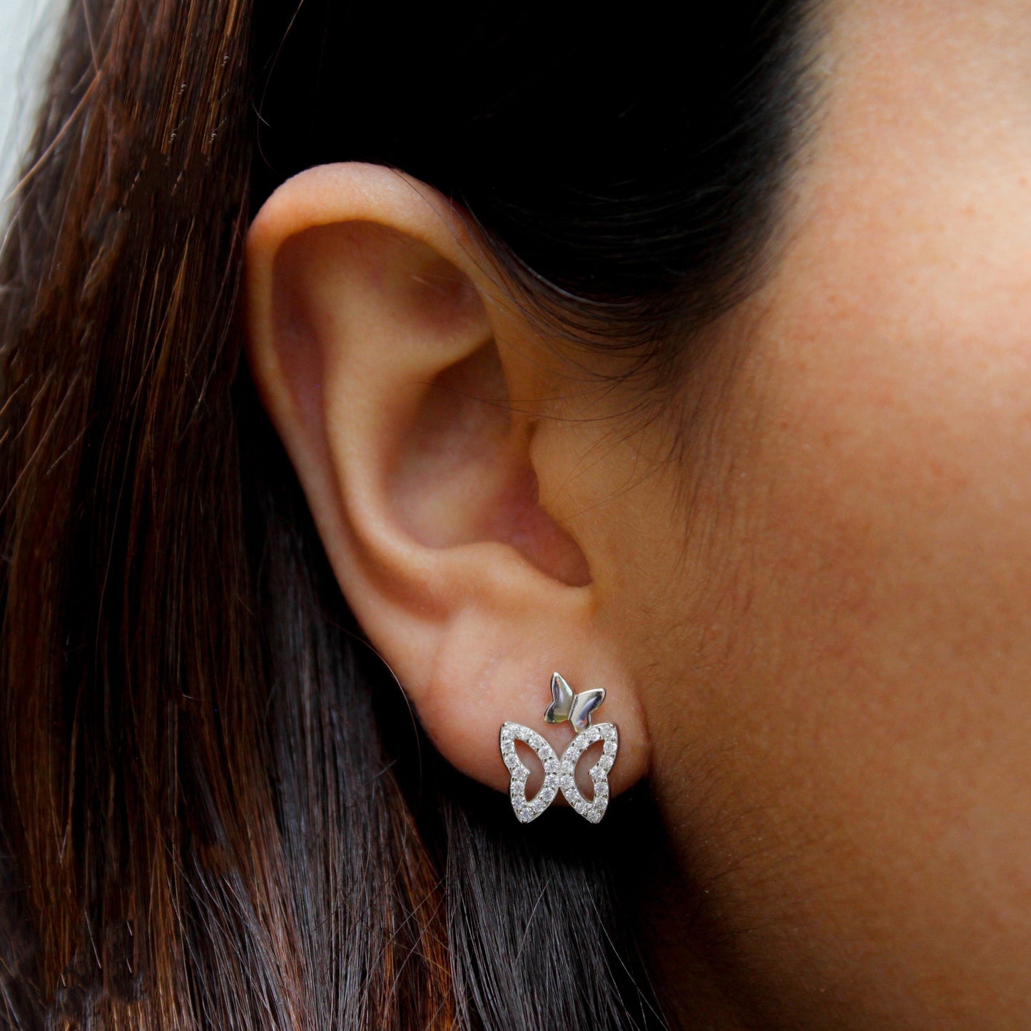 Mujer con aretes en forma de mariposa,
