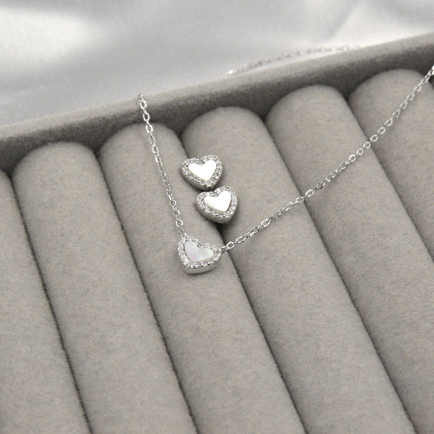 Juego de joyas de plata con corazones de madreperla y circonias, perfecto para un estilo romántico.