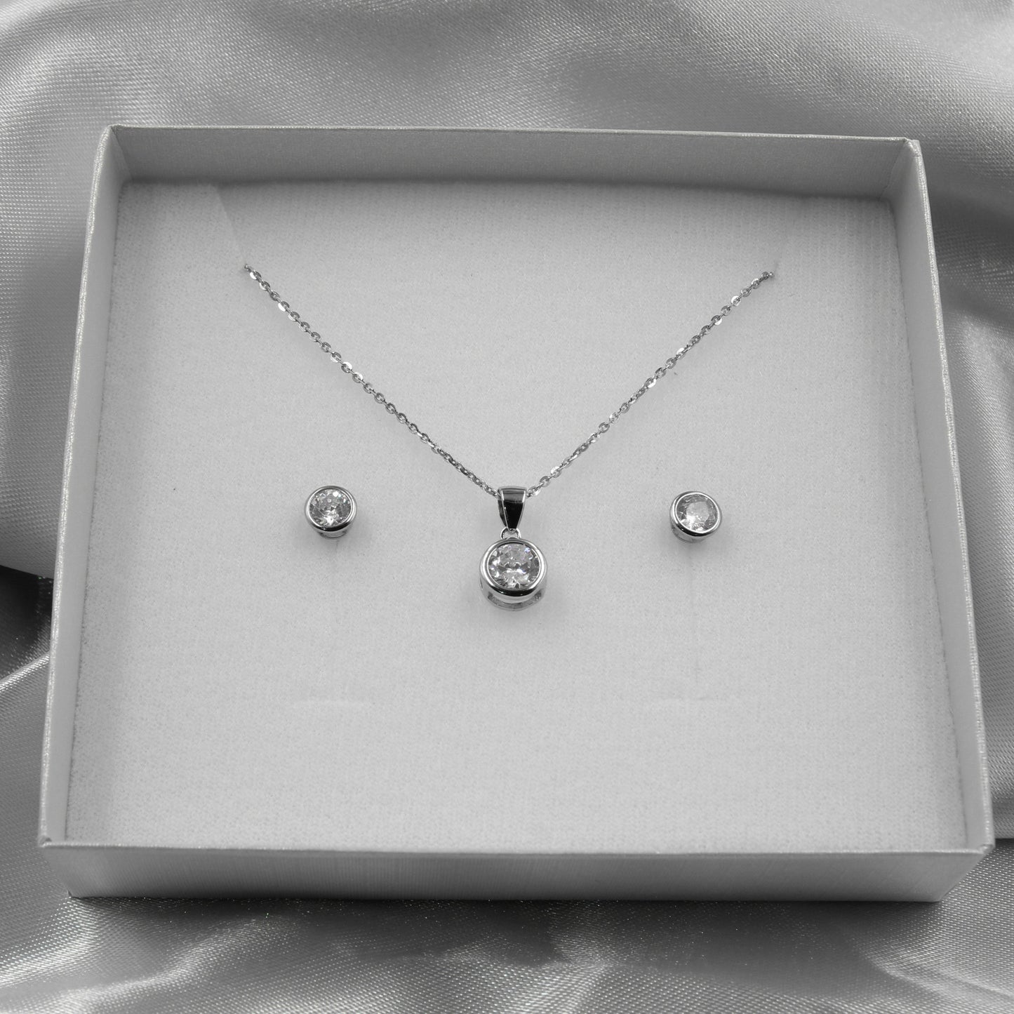 Elegante juego de joyas de plata con cristales redondos brillantes, ideal para eventos formales.