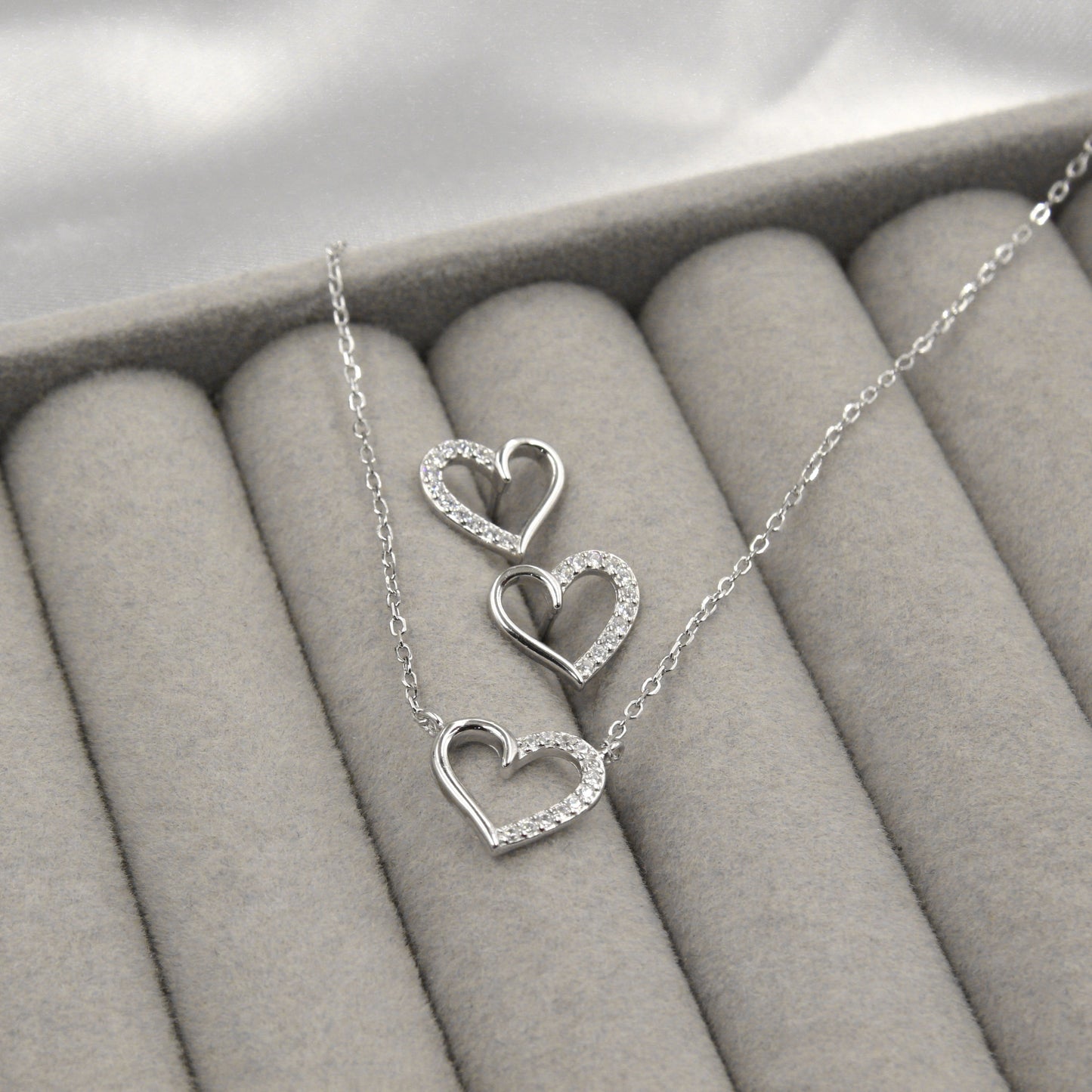 Juego de collar y aretes de plata 925 con diseño de corazones y zirconia cúbica.