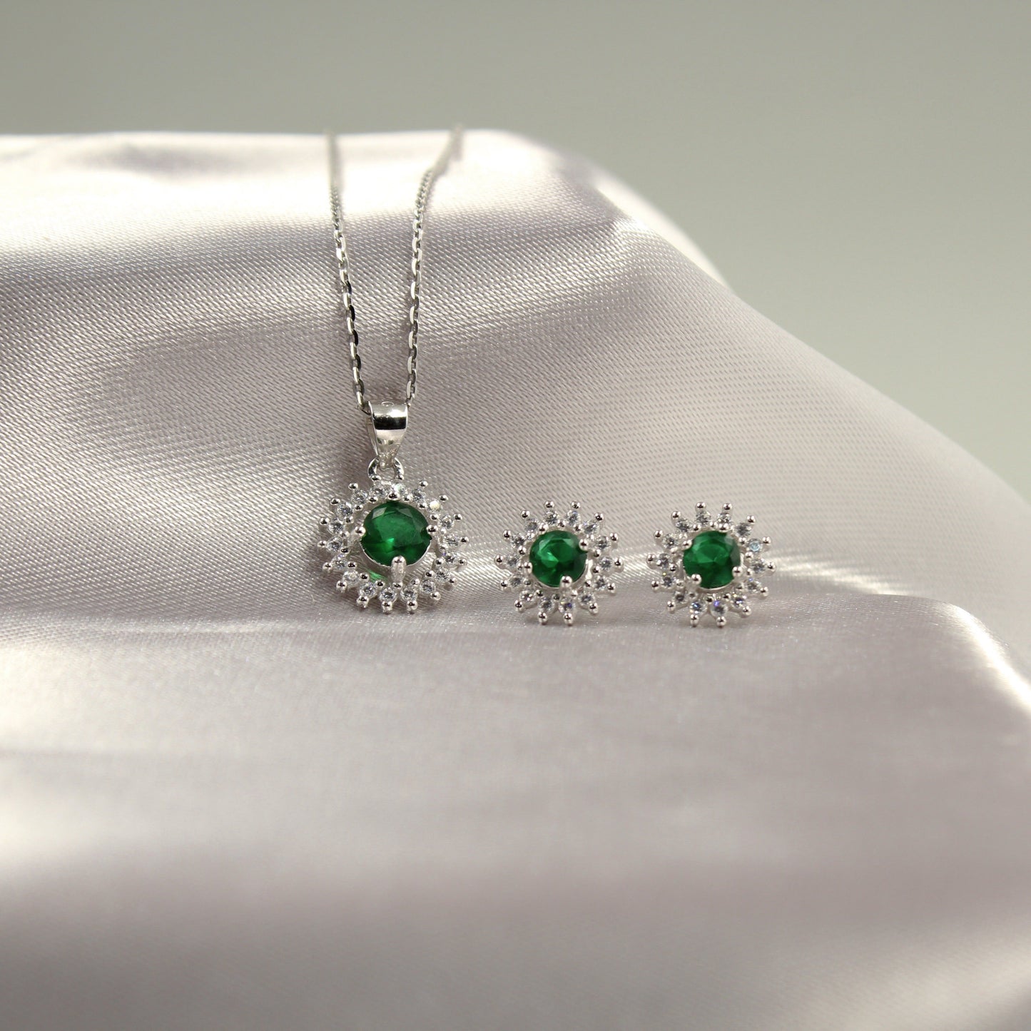 Juego de joyería con colgante y aretes de piedras verdes esmeralda.