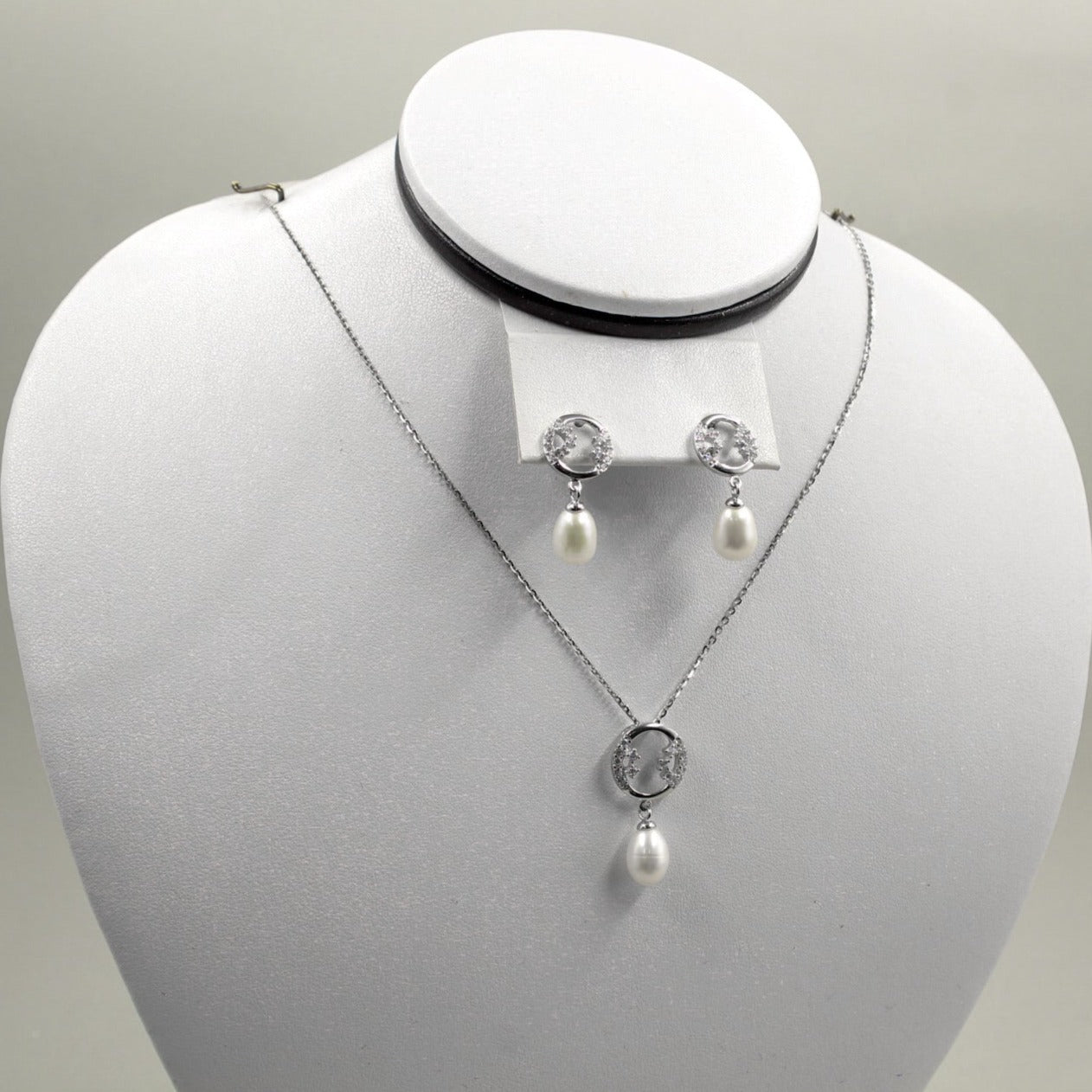 Juego de joyería con colgante y aretes de perla.