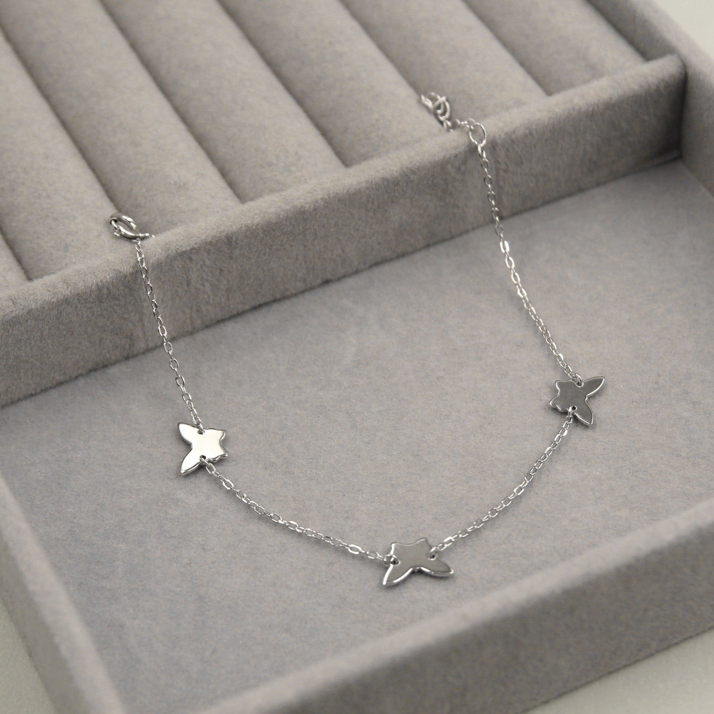 Pulsera de plata con colgantes de mariposas.