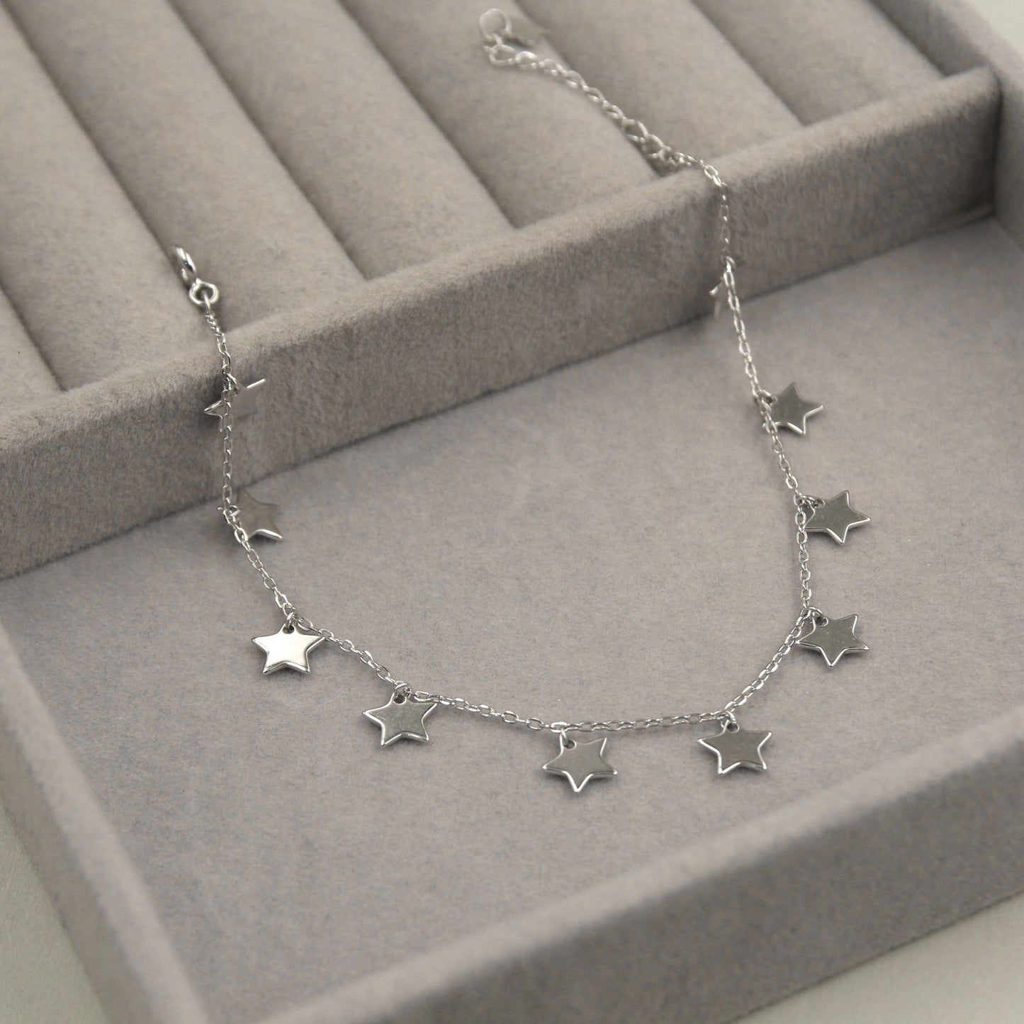 Pulsera de plata con dijes de estrellas.