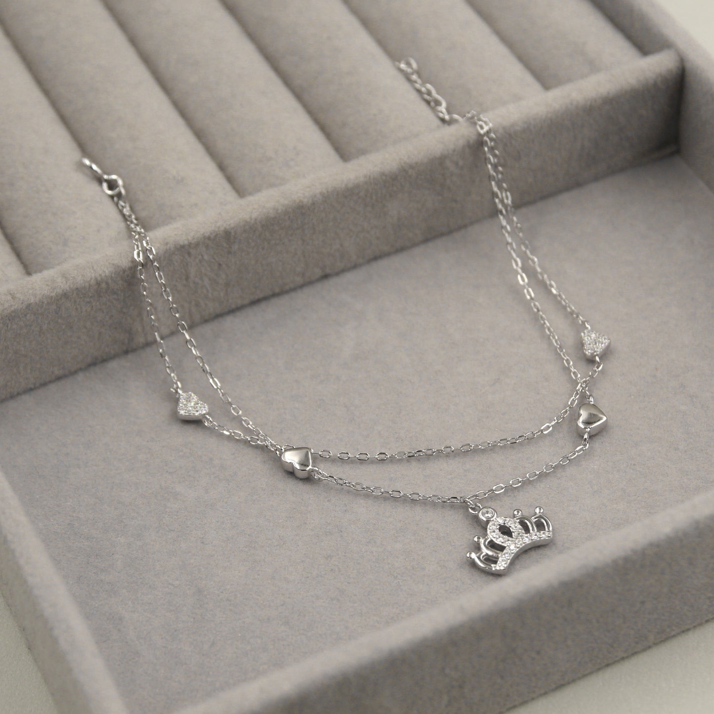 Pulsera de plata con corazones y corona.