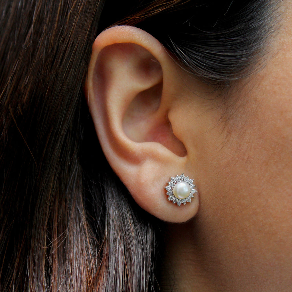 Mujer con aretes en forma de roseta con perla.