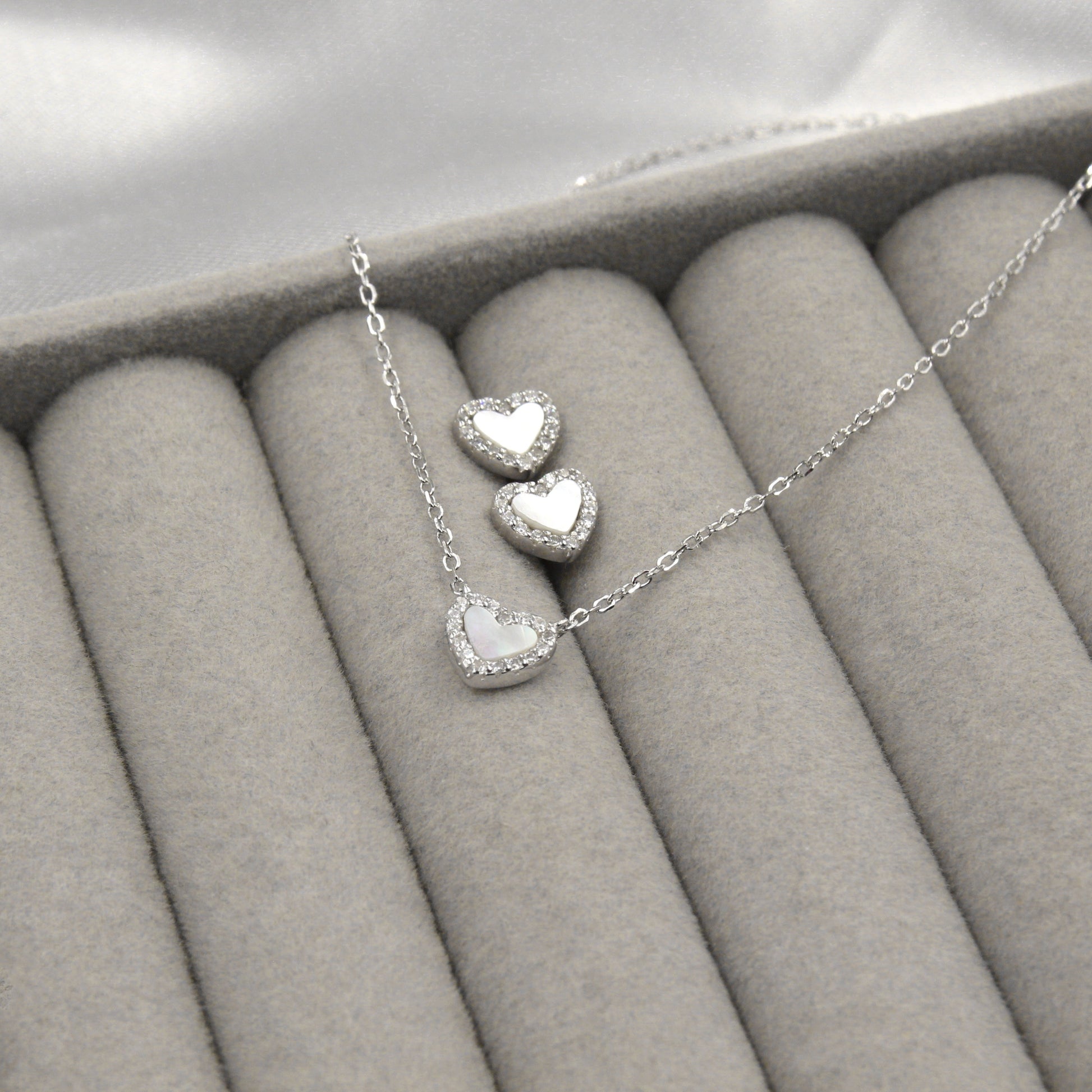 Juego de joyas de plata con corazones de madreperla y circonias, perfecto para un estilo romántico.