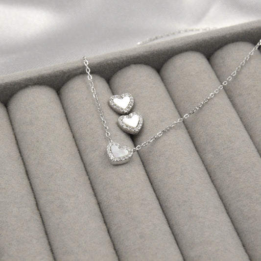 Juego de joyas de plata con corazones de madreperla y circonias, perfecto para un estilo romántico.