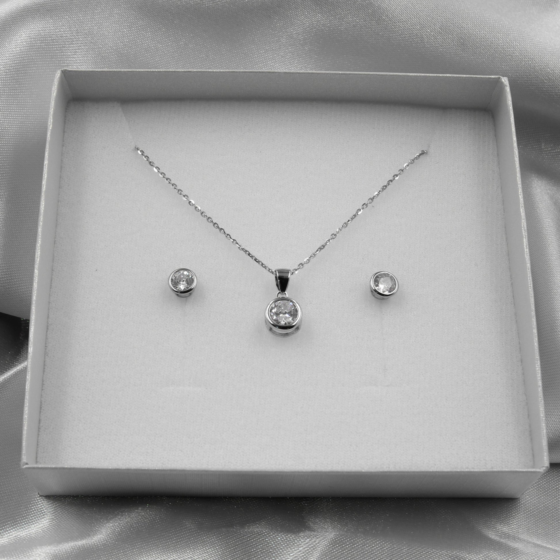 Elegante juego de joyas de plata con cristales redondos brillantes, ideal para eventos formales.