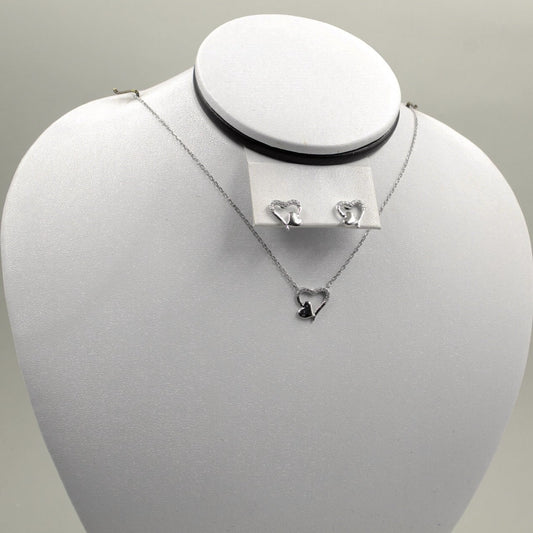 Juego de joyería con colgante y aretes de corazón plateado.
