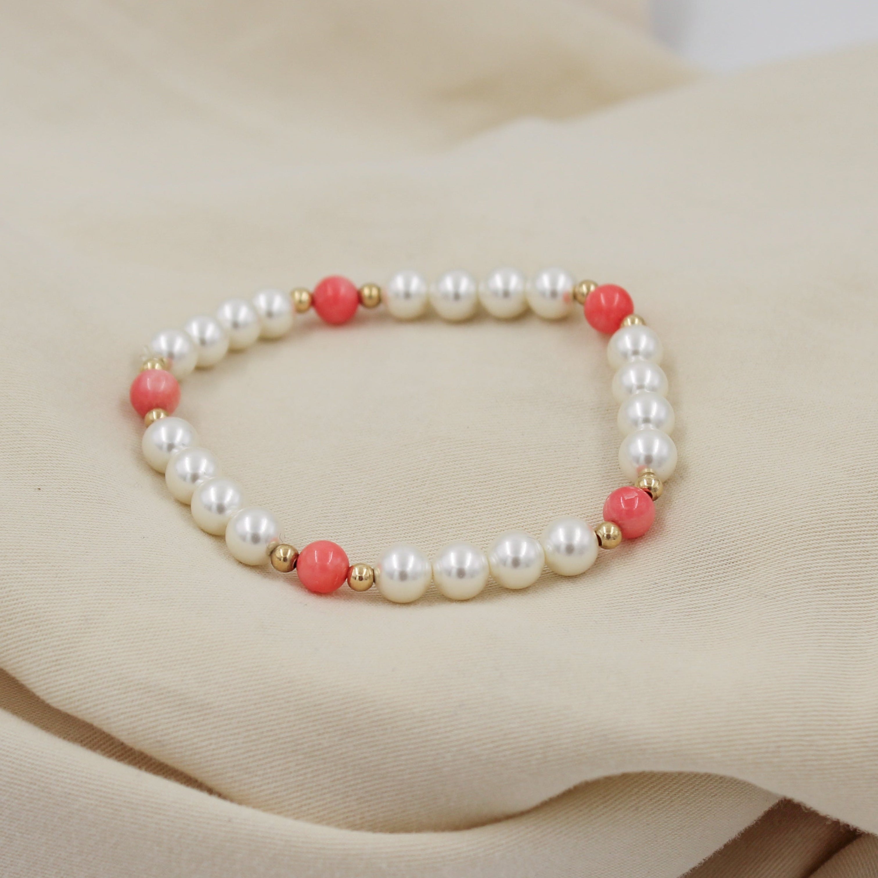 Pulsera de cuentas de madre perla con detalles en coral rosa y separadores goldfilled, tamaño 18 cm.